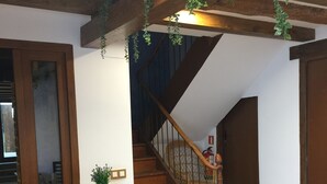 A wooden staircase with a railing, a wooden barrel, and a potted plant. - Apartment for two adults and two children ski Formigal Panticosa VTT (Senegüé)