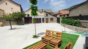 A courtyard with a grassy area, wooden benches, and a small tree. - Apartment for two adults and two children ski Formigal Panticosa VTT (Senegüé)