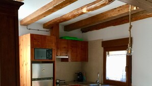 A kitchen with wooden cabinets, a stainless steel refrigerator, a built-in oven, a window, and a hanging light fixture. - Apartment for two adults and two children ski Formigal Panticosa VTT (Senegüé)