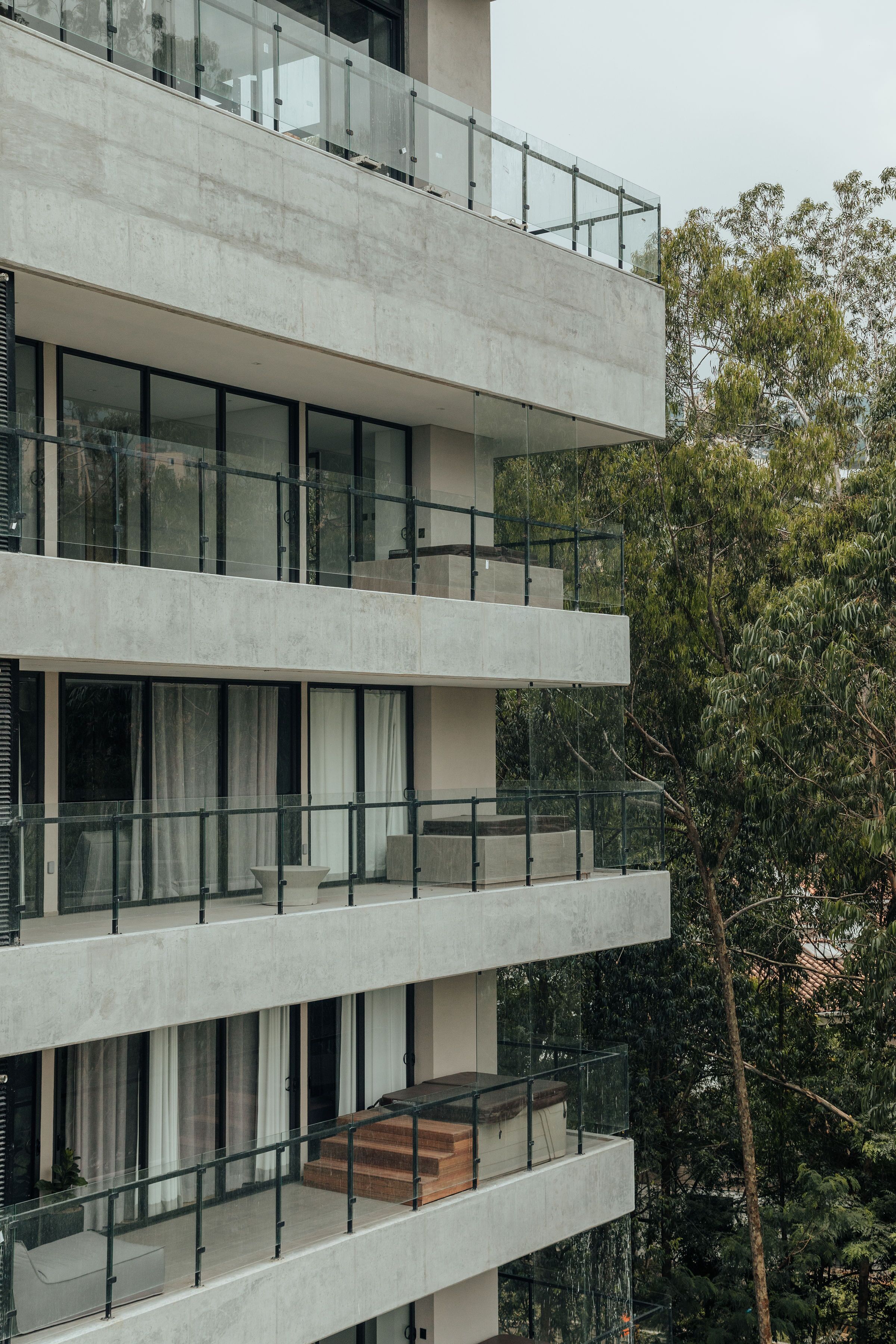 Un immeuble à plusieurs étages doté de grandes fenêtres et de balcons.