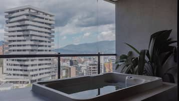 Uma casa de banho moderna com uma janela ampla, uma banheira e vista para a cidade.