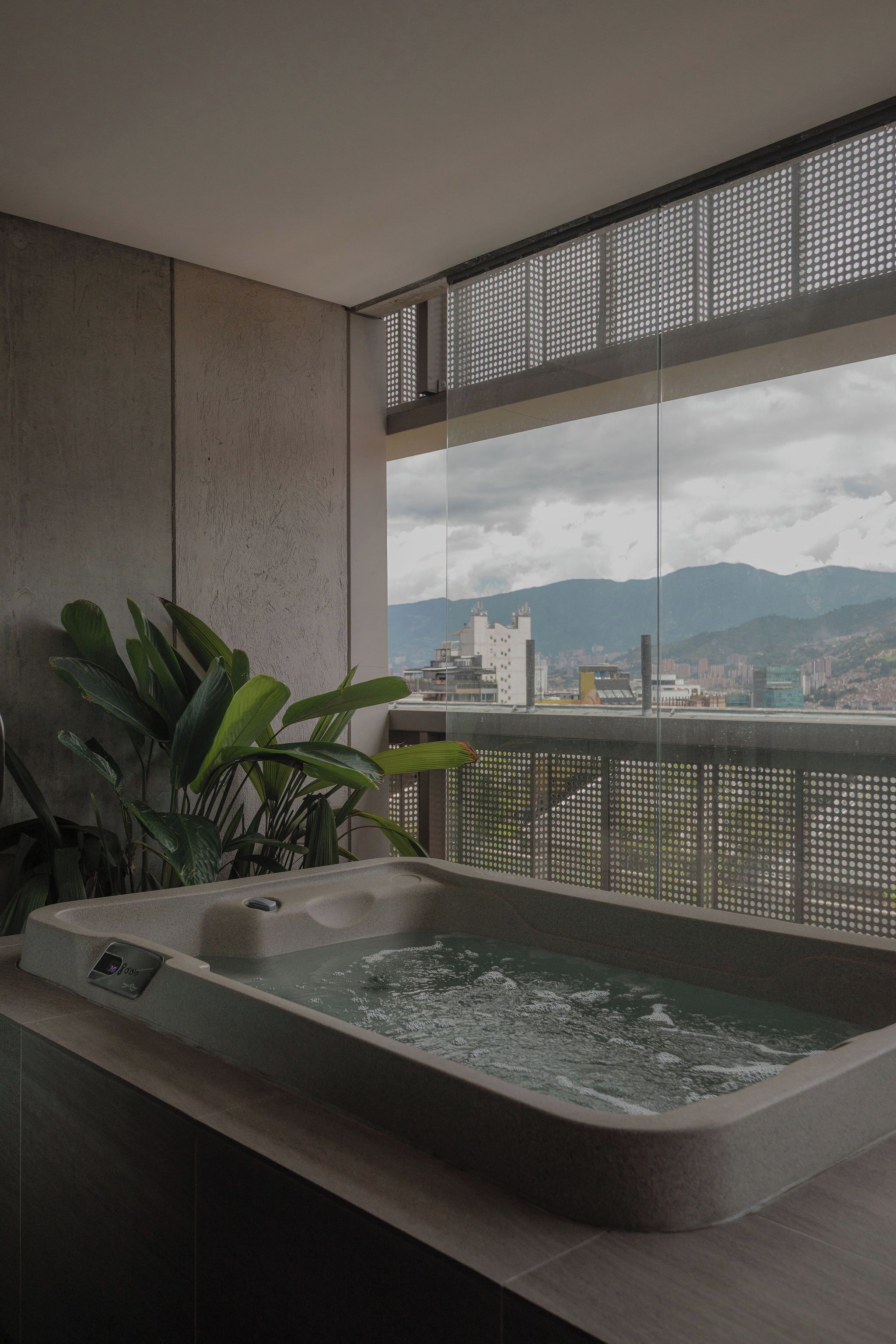A spa area with a hot tub, large windows, and a view of a cityscape.