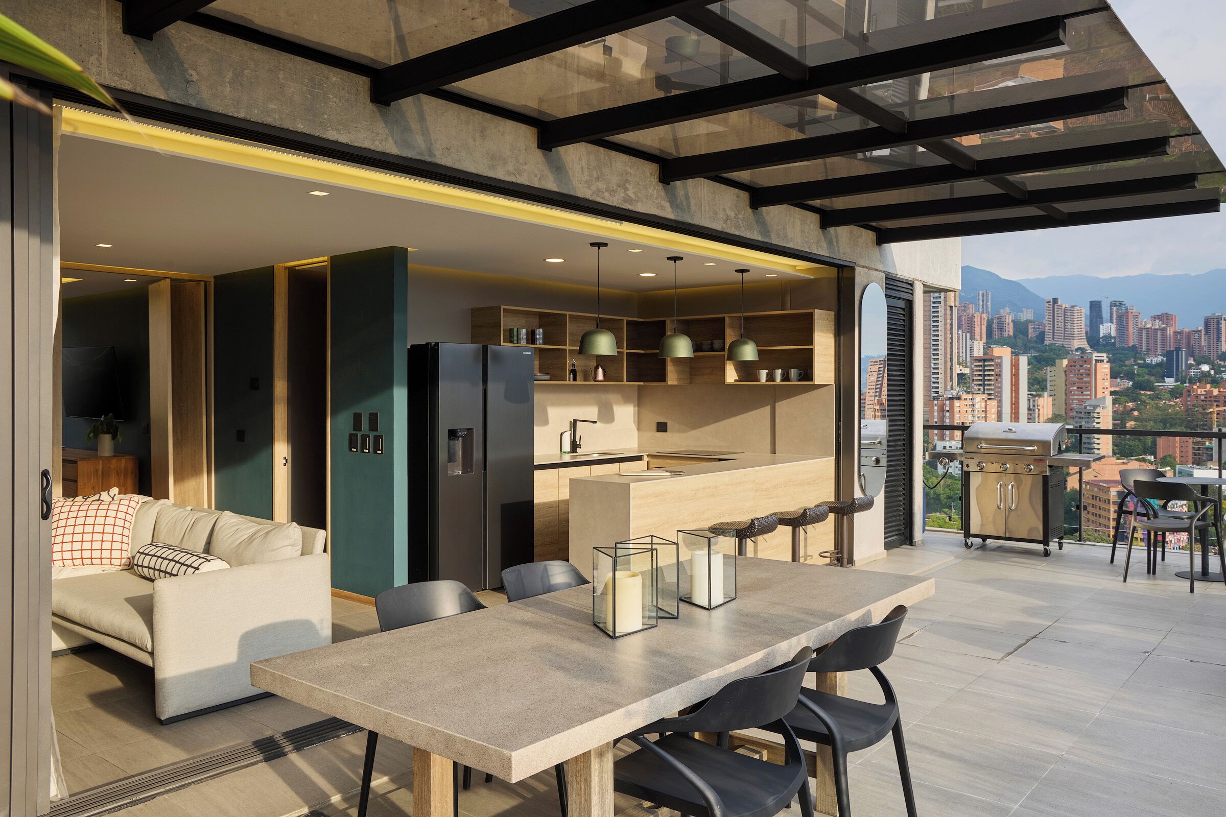 A modern kitchen with built-in appliances, a dining area with a table and chairs, and a view of a cityscape.