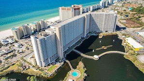 Een groot hotelcomplex met meerdere hoge gebouwen, een jachthaven en een strand.