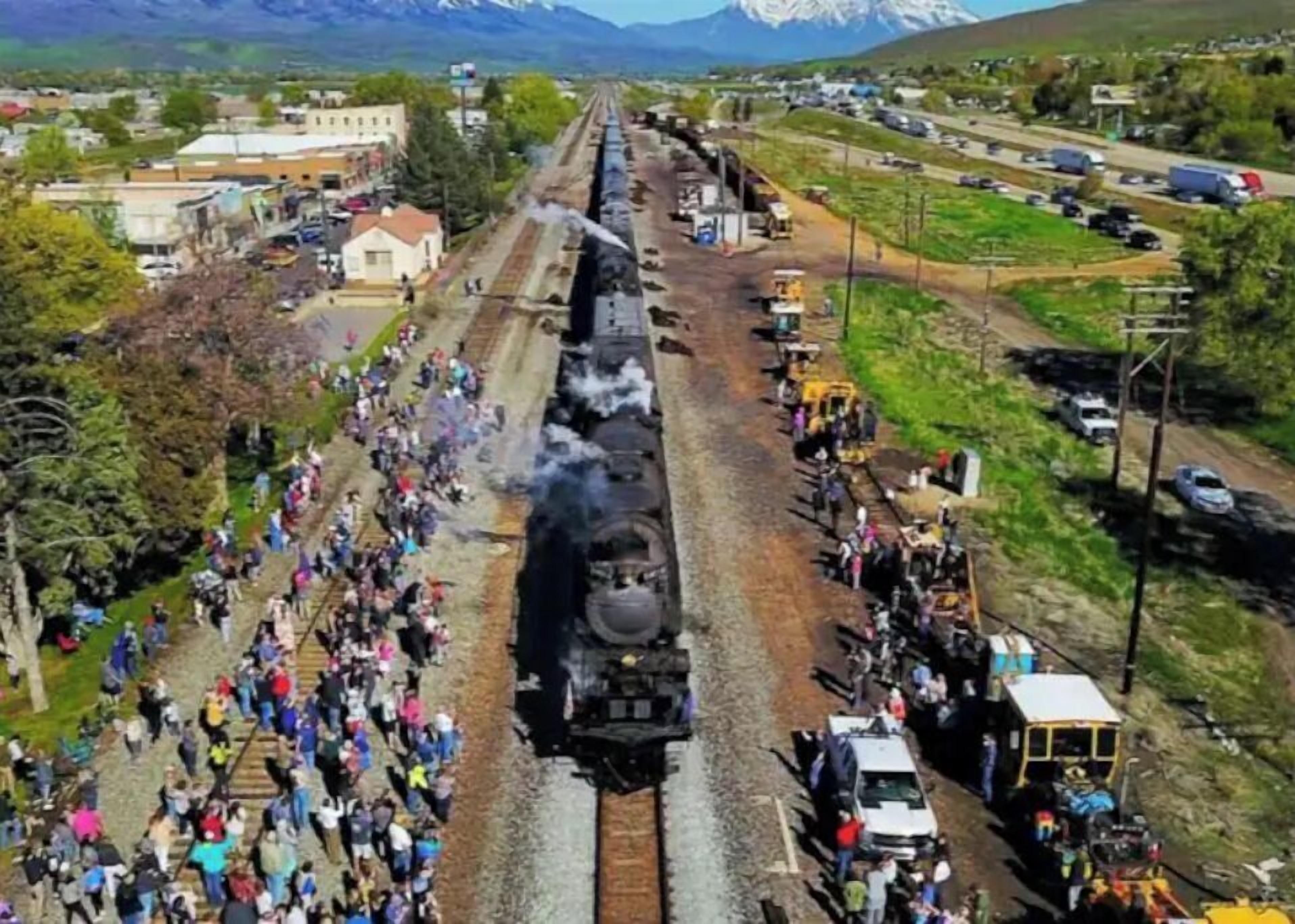 A steam locomotive at a railway station with a crowd of people.