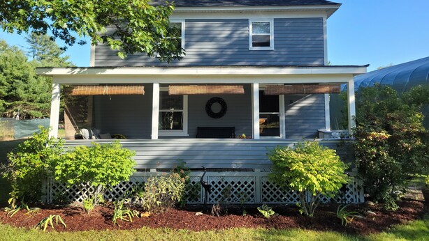 A two-story house with a front porch, a chimney, and a small garden area with plants and a bird feeder. - Sleeps 10, close to shopping centers on quiet dead end street. (Brunswick)