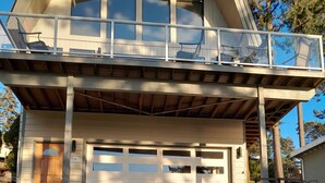 Une maison à deux étages avec un garage fermé et un balcon.