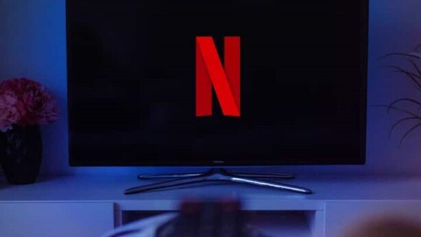 Un televisor con el logotipo de Netflix sobre un pedestal blanco.