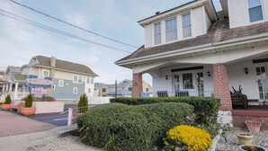 A hotel with a covered porch, a brick facade, and a sign for 'Port O'Call Hotel'. - Easy beach access!  3 bedroom, 2.5 Bath, a must see! (Ocean City)