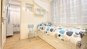 A bedroom with a bed, a chair, a small cabinet, and a window with a patterned curtain. - Amelio, Apartment 5StarsHome Mallorca (Puerto Pollensa)