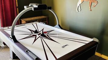 A billiards table with a star design, a wall-mounted deer decoration, and a sign reading 'CABINSWEETCABIN'.