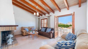 A spacious living area with a fireplace, a sofa set, and a view of the outdoors. - Palmestar, Finca 5StarsHome Mallorca (Puerto Pollensa)