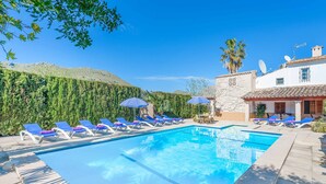 A swimming pool with lounge chairs and umbrellas, surrounded by a landscaped garden and a hillside. - Palmestar, Finca 5StarsHome Mallorca (Puerto Pollensa)