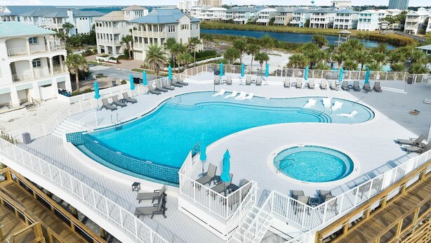 A large outdoor swimming pool with multiple deck levels, surrounded by white railings and lounge chairs. - Private Pool & Spa Walk to 2 Beaches (Destin)