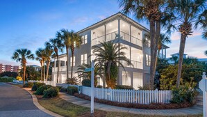 A modern two-story building with a balcony, surrounded by palm trees and a white picket fence. - Private Pool & Spa Walk to 2 Beaches (Destin)