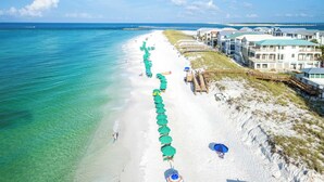 A beach resort with a long row of beach umbrellas, a sandy beach, and ocean views. - Private Pool & Spa Walk to 2 Beaches (Destin)