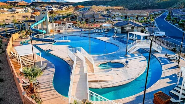 Een resort met diverse zwembaden, een glijbaan en uitzicht op het omliggende landschap.