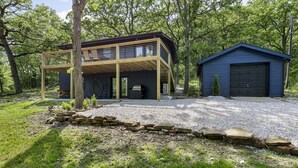 Una casa moderna con porche cubierto, garaje y un sendero de piedra.