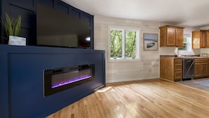 Una cocina moderna con armarios de madera, horno integrado y un ventanal grande.