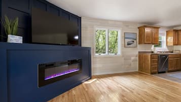 A modern kitchen with wooden cabinets, a built-in oven, and a large window.