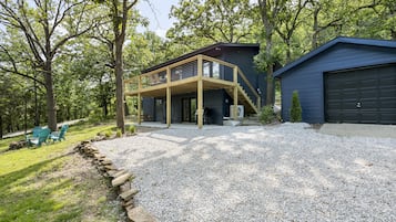 Une maison moderne dotée d’un patio couvert, d’un garage et d’une allée gravillonnée.