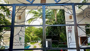 A metal gate with the words "WAKOONT" and "CRISTO" in blue letters, leading to a building with a white facade and a tiled entrance. - Perfect Cozumel escape, pool, private beach on quiet north shore (San Miguel de Cozumel)