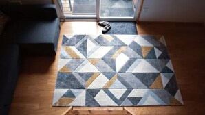 A geometric-patterned rug on a wooden floor with a staircase leading to a room. - A-Frame Cabin - 5 Mins to NP - Tilted Timbers (Ashford)