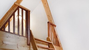 Un espace de vie de style loft avec un escalier en bois, une cheminée et un coin salon confortable.