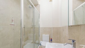 A bathroom with a glass-enclosed shower, a white sink, and a toilet. - Peaceful 1BD Flat, 5 mins from Highbury &Islington (London)