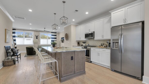 A modern kitchen with white cabinets, stainless steel appliances, and a central island. - Downtown Greenville · 3BR/3.5BA · Private 2-Car Garage · Minutes to Main St (Greenville)