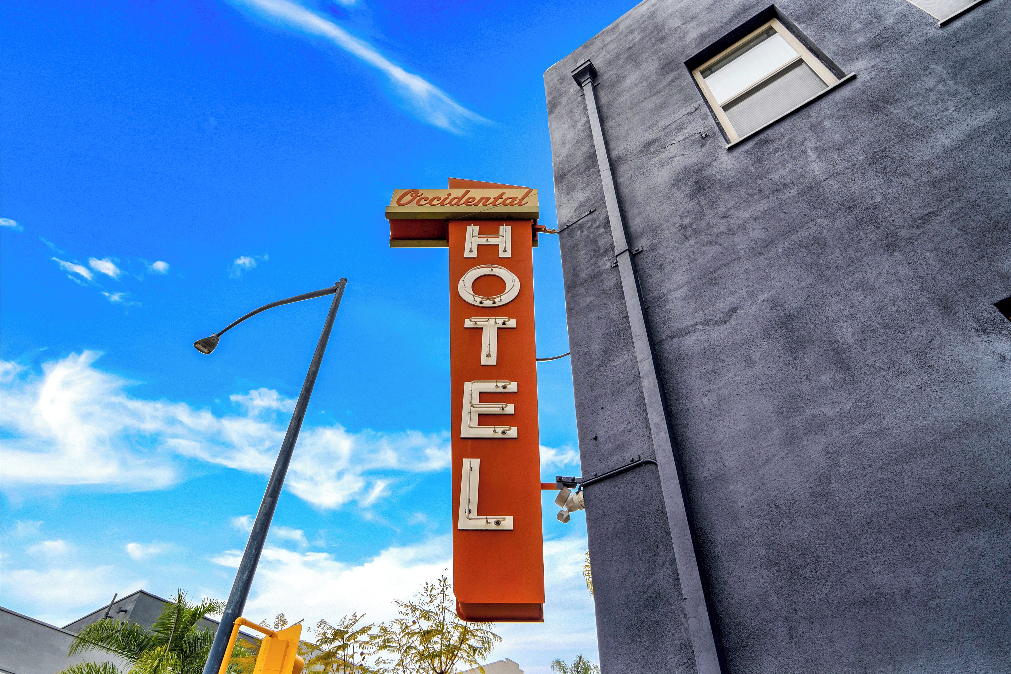 A hotel sign with the name "Occidental Hotel" mounted on a building.