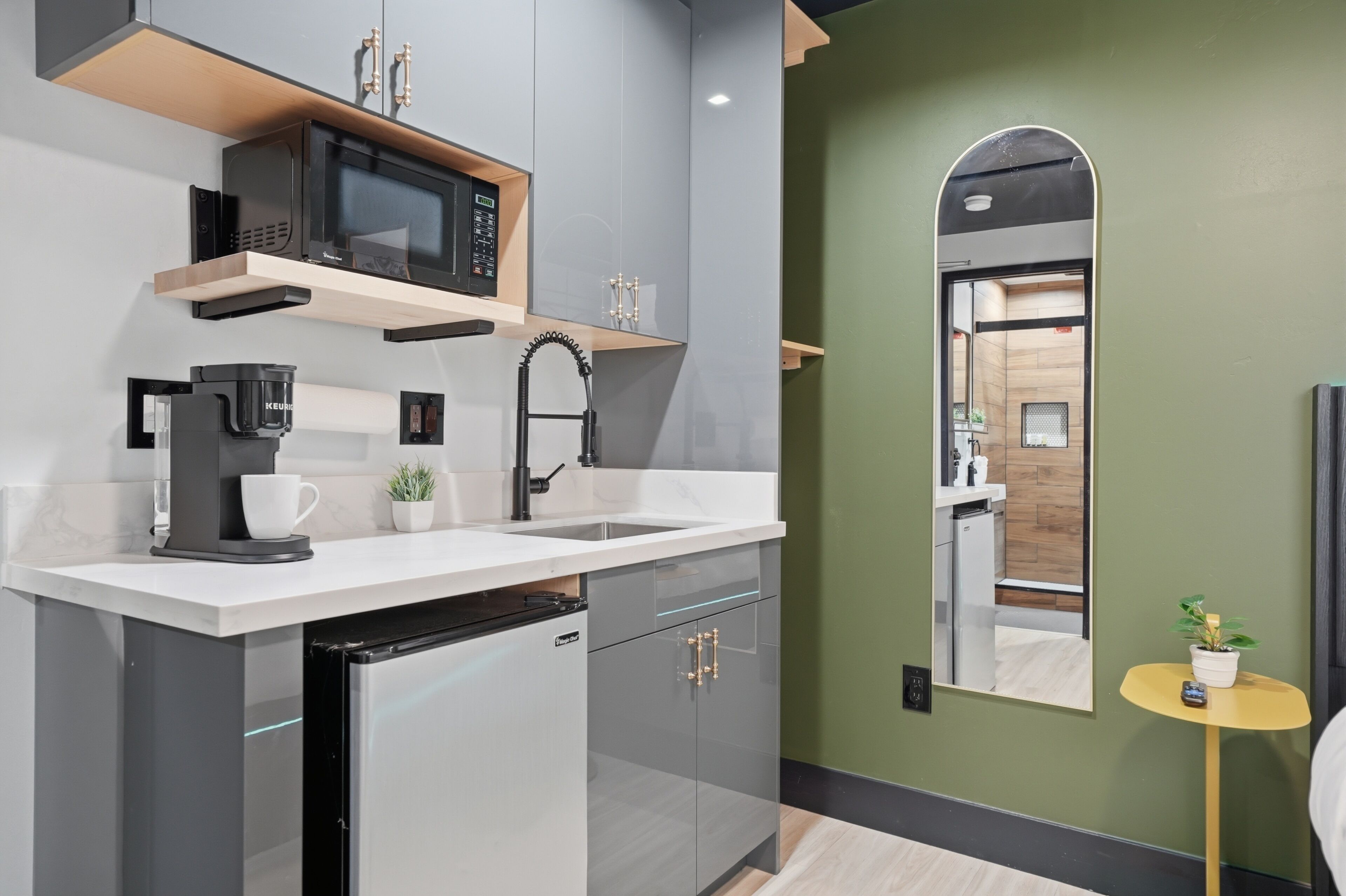 A modern kitchen with a microwave, coffee machine, and dishwasher.
