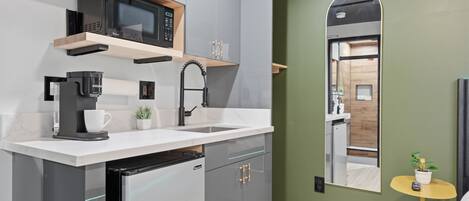 A modern kitchen with a microwave, coffee machine, and dishwasher.