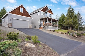 A two-story house with a garage, a covered porch, and a driveway leading to the entrance.