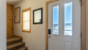 A staircase leading to a door with a view of a snowy landscape. - Centrally Located Cozy Townhome in Fraser (Fraser)