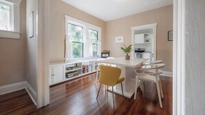 A kitchen with a white countertop, two yellow chairs, and a white cabinet. - Historic Bungalow w/Game Room by Downtown Tampa! (Tampa)