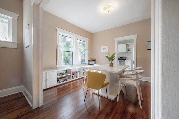A kitchen with a white countertop, two yellow chairs, and a white cabinet.