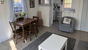 Een compacte leefruimte met een eethoek, een kitchenette en een zithoek.