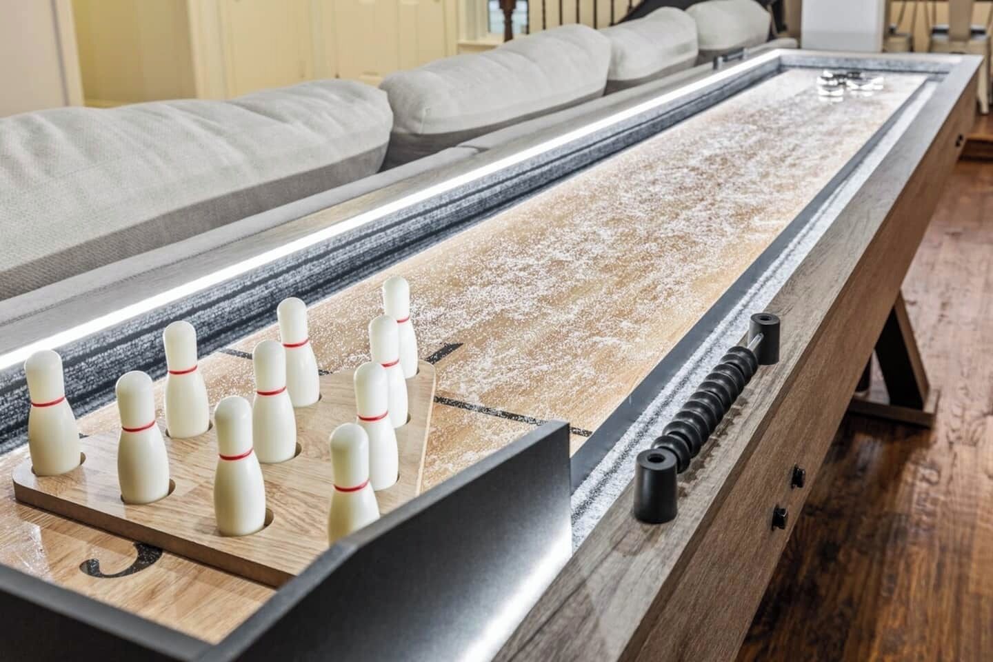 Una bolera de madera con los bolos colocados.