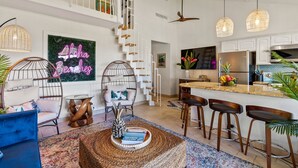 A modern kitchen with a central island, bar stools, and a ceiling fan. - Oceanfront Stunner w/ Cruiser Bikes & Pickleball (Kihei)