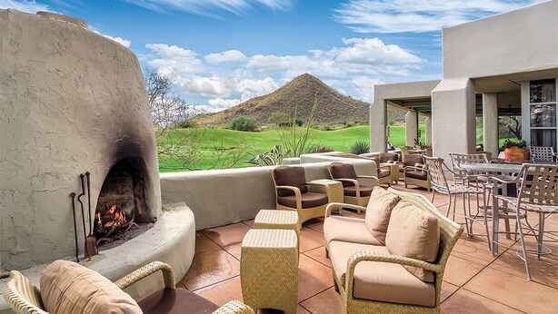A patio with outdoor furniture, a fire pit, and a view of a green landscape and hill. - Starr Pass Spring Golf Retreat - April 12-15 - 1 Bedroom Condo (Tucson)