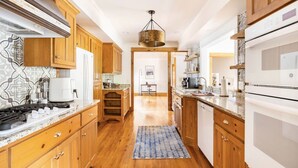 Una cocina moderna con armarios de madera, una isla central y un lámpara colgante.