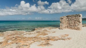 A stone structure near a beach with clear turquoise water and a clear sky. - Beachfront Sunset Oasis  Adult-Only, Pool & Views (Frederiksted)