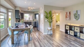 A modern kitchen with a dining area, a large potted plant, and artwork on the walls. - Garden view home - near major higways w/high chair, pack&play, baby bathtub ways (Phoenix)