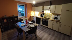 Una cocina compacta con una mesa de comedor, sillas y electrodomésticos básicos.