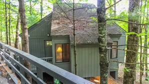 A rustic cabin with a wooden deck and a window with blinds. - Golf Club Villas (Marble Hill)