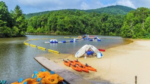 A lakeside campsite with kayaks, a tent, and a small boat dock. - Golf Club Villas (Marble Hill)