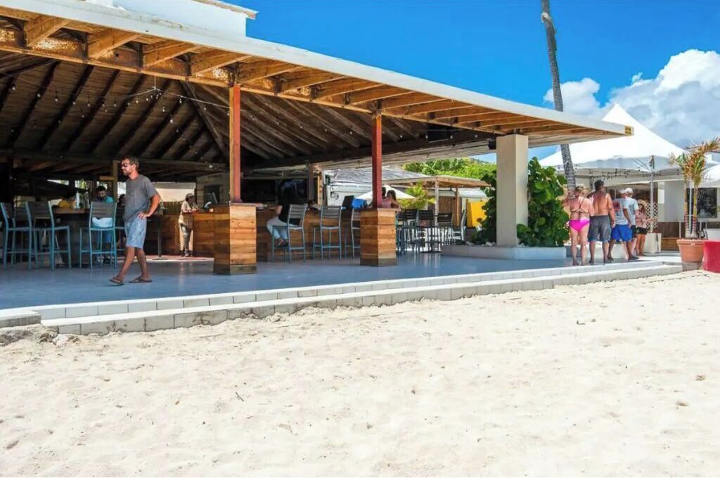 Ein Restaurant am Strand mit Außenbestuhlung und einer überdachten Terrasse.
