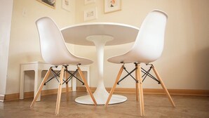 A round white table with two white chairs with wooden legs. - Cozy Modern Garden Flat (Westerville)