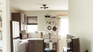 A modern kitchen with stainless steel appliances, wooden cabinets, and a built-in oven.